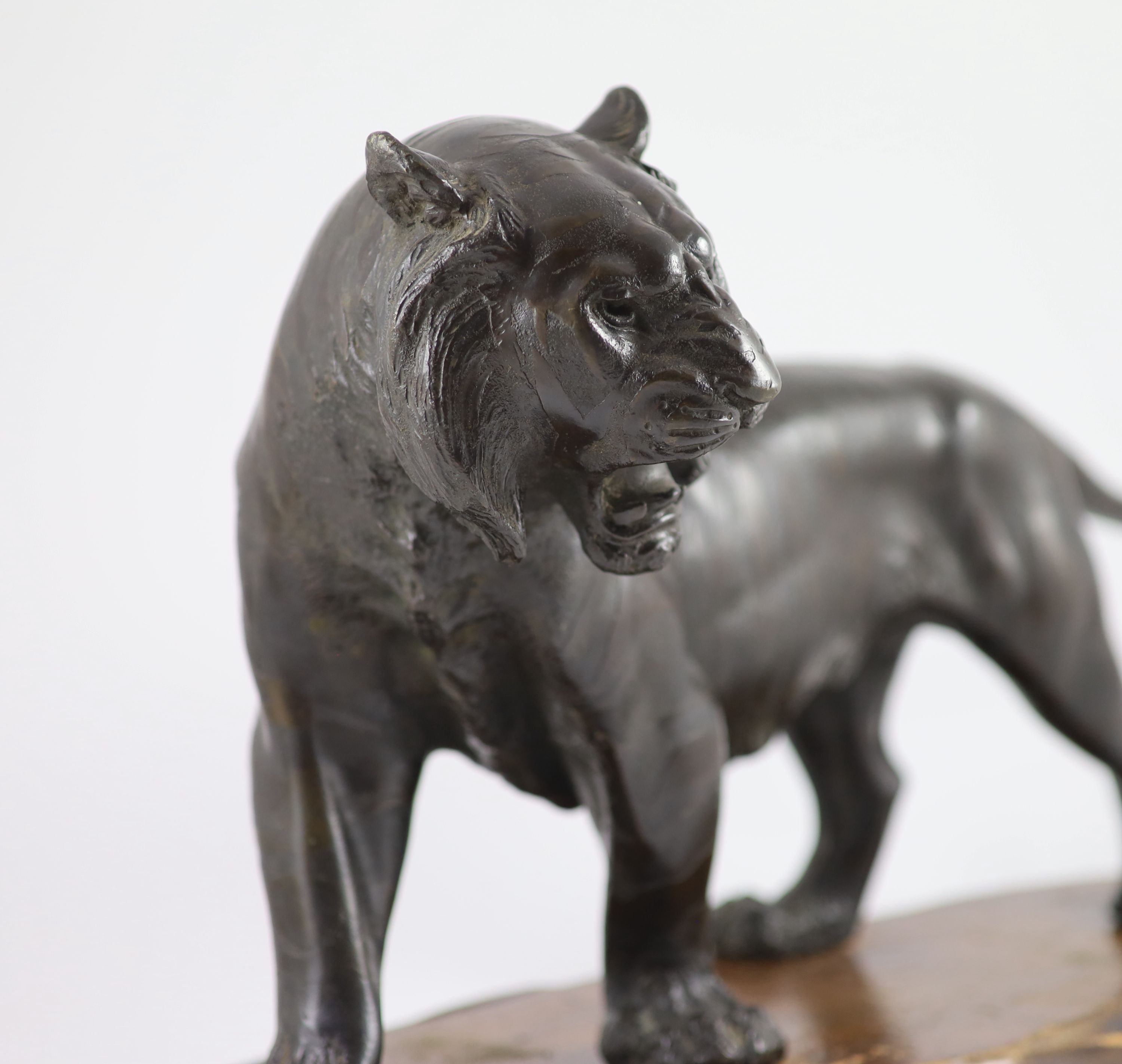 A large Japanese Meiji bronze model of a stalking tiger, Meiji period, 58.5 cm long, wood stand